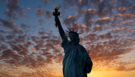 The silhouette of Statue of Liberty under sunrise backgroundの写真素材