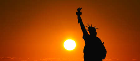 The silhouette of Statue of Liberty under sunrise backgroundの写真素材
