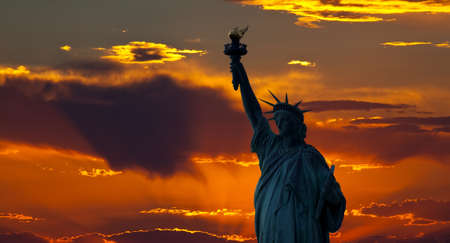 The silhouette of Statue of Liberty under sunrise backgroundの写真素材
