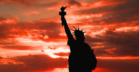 The silhouette of Statue of Liberty under sunrise backgroundの写真素材