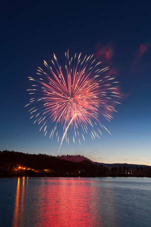 Fireworks Exploding Over a Mountain Lake.の写真素材