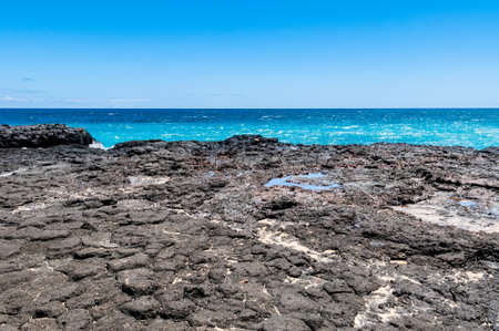 Blue Sky, Blue Pacific Ocean, Sand and Lava Rocks in Kauai, Hawaii