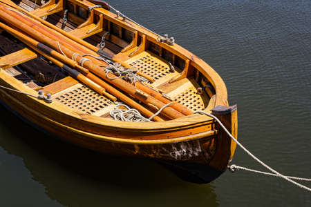 Vintage wooden skiff with oars, rope and other tackle.