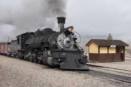 Vintage Railroad Steam Locomotive on a snowy day in the mountains.