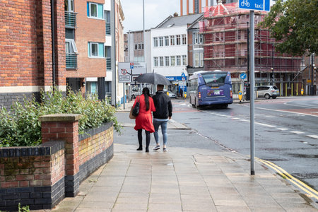 08/12/2019 Portsmouth, Hampshire, UK a couple walking together under an umbrella sheltering from the rainのeditorial素材