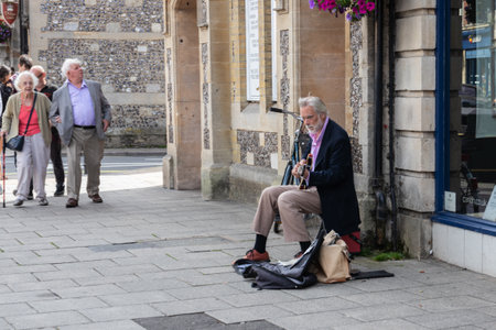 09/02/2019 Winchester, Hampshire, UK a middle aged well dressed street busker playing the guitarのeditorial素材