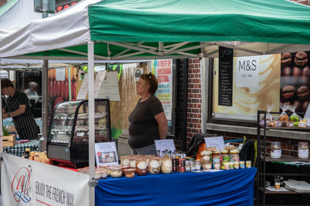 09/02/2019 Winchester, Hampshire, UK A market stall holder standing behind her stall waiting for customersのeditorial素材