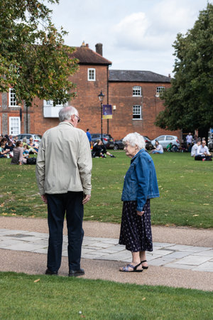 09/02/2019 Winchester, Hampshire, UK An elderly man and woman standing in a park talkingのeditorial素材
