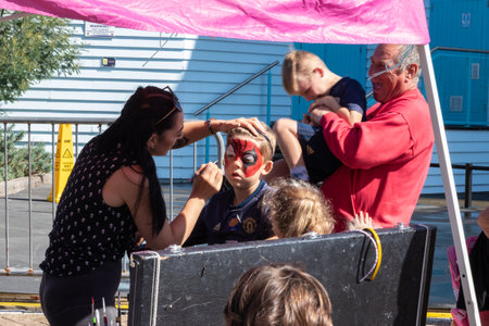 09/14/2019 Portsmouth, Hampshire, UK a child having their face painted and a fate or fair by a face painting artistのeditorial素材