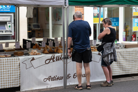 09/02/2019 Winchester, Hampshire, UK A middle aged couple looking at the food for sale on a market stallのeditorial素材