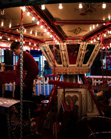 09/14/2019 Portsmouth, Hampshire, UK A fairground worker on a merry go round or carousel at nightのeditorial素材