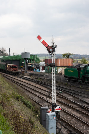 09/14/2019 Ropley, Hampshire, UK a green steam train next to a train signalのeditorial素材