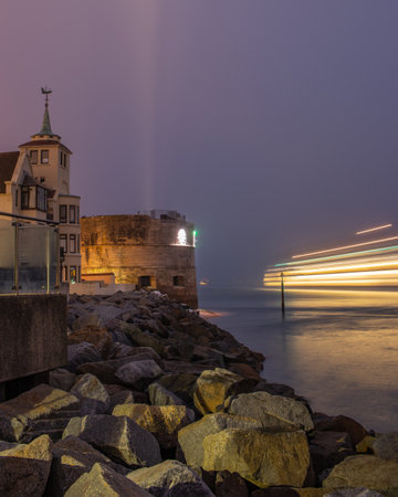 09/14/2019 Portsmouth, Hampshire, UK a ferry passing the round tower in portsmouth at nightのeditorial素材