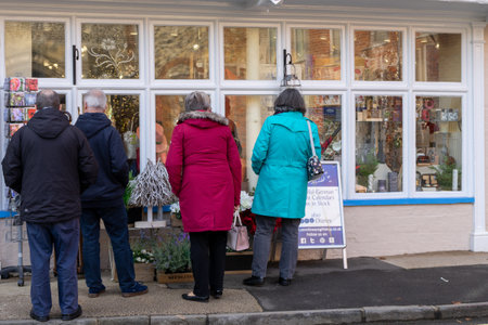 11/06/2019 Winchester, Hampshire, UK two middle aged couples looking in the window of a quaint english shopのeditorial素材