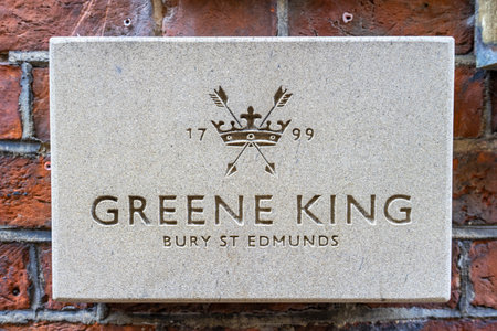 11/06/2019 Winchester, Hampshire, UK a stone Greene King sign outside a pub on a brick wallのeditorial素材