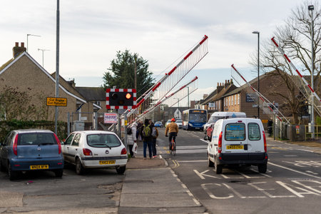 02/05/2020 Chichester, West sussex, UK Cars and pedestrians waiting for the railway gates to raise at a level crossingのeditorial素材
