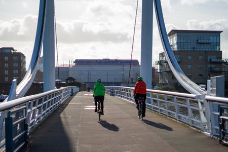 01/29/2020 Gosport, Hampshire, UK A couple riding their bikes over a modern bridgeのeditorial素材