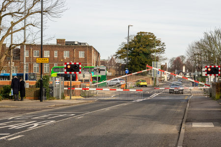 02/05/2020 Chichester, West sussex, UK Cars and pedestrians waiting for the railway gates to raise at a level crossingのeditorial素材