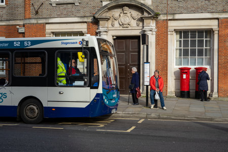 02/05/2020 Chichester, West sussex, UK A stagecoach bus at a bus stop with commuters waiting at the bus stop for their busのeditorial素材