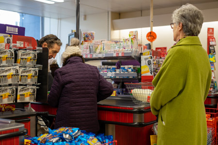02/05/2020 Chichester, West sussex, UK Shoppers queuing at the checkout of a supermarket putting produce on the conveyor beltのeditorial素材