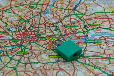 03/14/2020 Portsmouth, Hampshire, UK A locked padlock on top of a road map or geography map of London UKのeditorial素材
