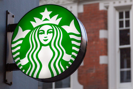 07/22/2020 Portsmouth, Hampshire, UK A lit up sign showing the logo of Starbucks coffee on the side of a buildingのeditorial素材