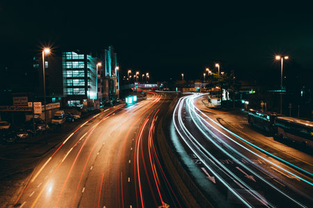 02/04/2020 Portsmouth, Hampshire UK, Car light trails at night passing a block of flats or apartments, showing movementのeditorial素材