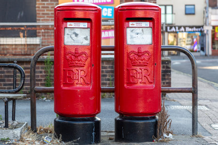 08/02/2020 Portsmouth, Hampshire, UK two red Royal mail post boxes side by side on a street with a sticker stating priority post boxのeditorial素材