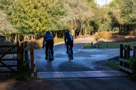 06/18/2019 Lymington, Hampshire, UK A pair of cyclists riding side by side on country roadsのeditorial素材