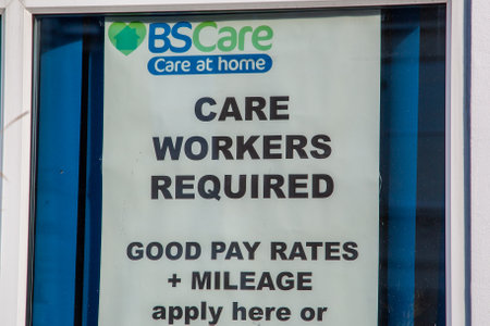 08/02/2020 Portsmouth, Hampshire, UK a sign in the window of an employment agency stating care workers required and the rates of pay or wagesのeditorial素材
