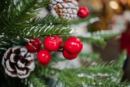 Red berries and frosted pine cones on a christmas treeの写真素材
