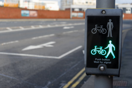A pedestrian crossing button and warning sign showing green to show you can cross the roadの写真素材