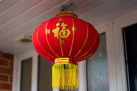 A chinese red lantern hanging in a doorway for chinese new year Translated as happy new yearの写真素材