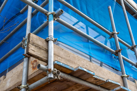 scaffolding poles and screen on a building on a construction site or building siteの写真素材