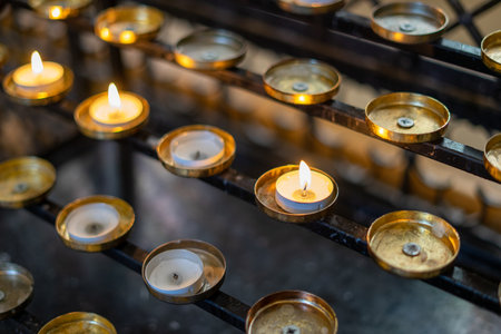 candles lit on a stand in a church in remembranceの写真素材