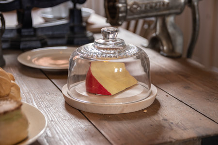 a block of cheese under a cheese or cake domeの写真素材