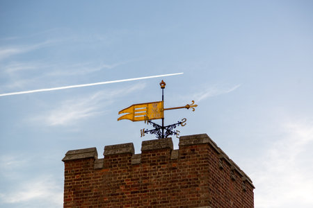 A weather vane on the top of an old brick buildingの写真素材
