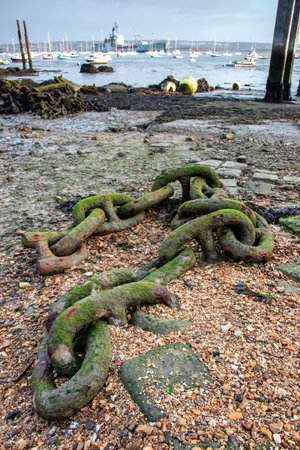 an old iron anchor chain at the seaside at low tideの写真素材