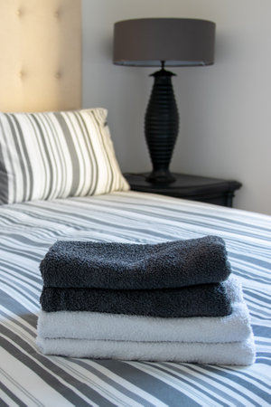 towels laid on a bed in a hotel roomの写真素材
