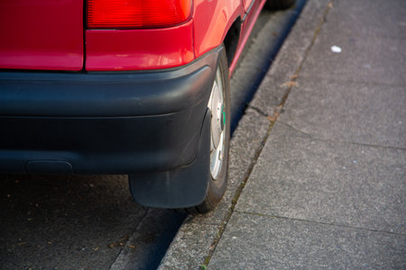 the wheel of a badly parked car parked on a curbの写真素材