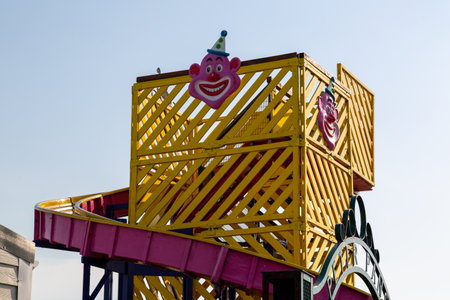 The top of a children's funfair slide or helter skelter with a clowns face on itの写真素材