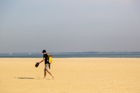 09/15/2020 Ryde, Isle of Wight, UK A man walking barefoot on a golden sandy beach, Ryde, Isle of wightの写真素材