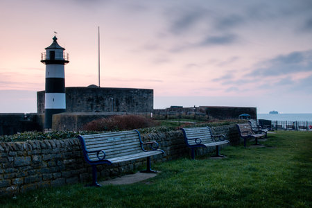 Empty benches in front of Southsea Castle at sunrise, Southsea, Portsmouth, UKの写真素材