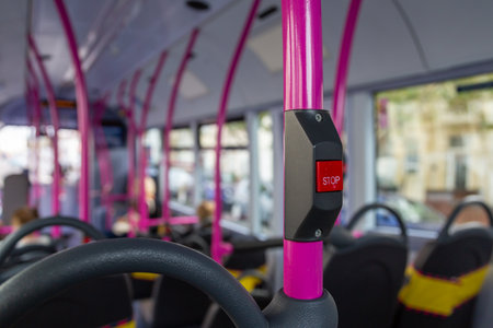 A close up of the stop button in the interior of a bus used to alert the bus driver that you would like to get off at the next bus stopの写真素材