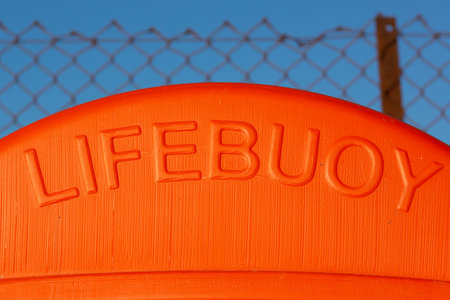 The word lifebuoy on an orange container that hold a life ringの写真素材