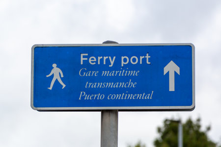 A sign on a lamppost pointing pedestrians to the ferry port in English, French and Spanishの写真素材