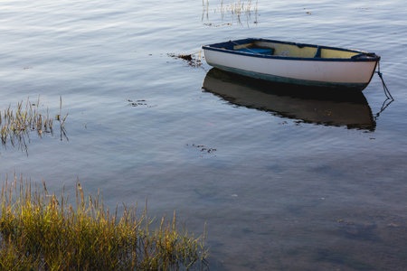 An old wooden boat moored in a calm marinaの写真素材
