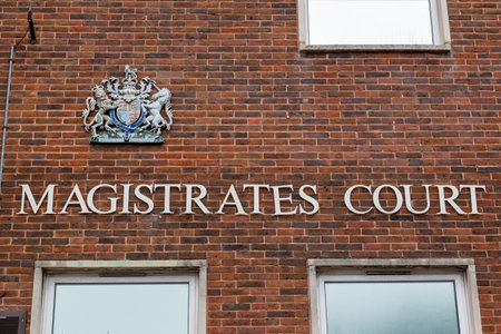 the sign on the exterior or facade of a magistrates court with the royal crest above itの写真素材