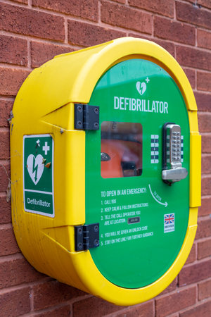 A defibrillator or AED in a secure case on a brick wall in the streetの写真素材
