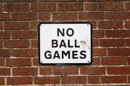 A No ball games sign on a brick wall on the side of a propertyの写真素材